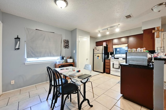 kitchen featuring white range with electric cooktop, freestanding refrigerator, under cabinet range hood, a textured ceiling, and light tile patterned floors