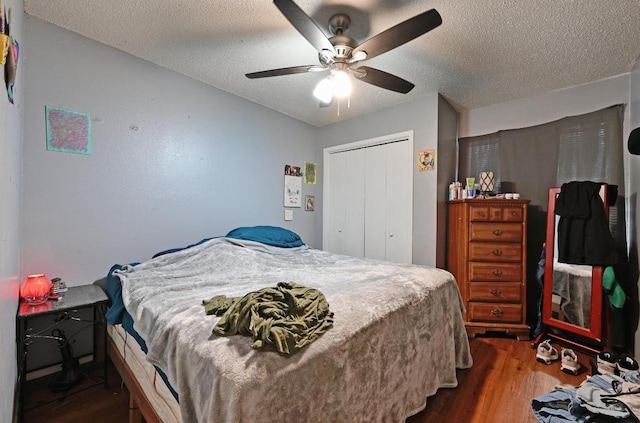 bedroom with dark wood-style floors, a closet, a textured ceiling, and a ceiling fan