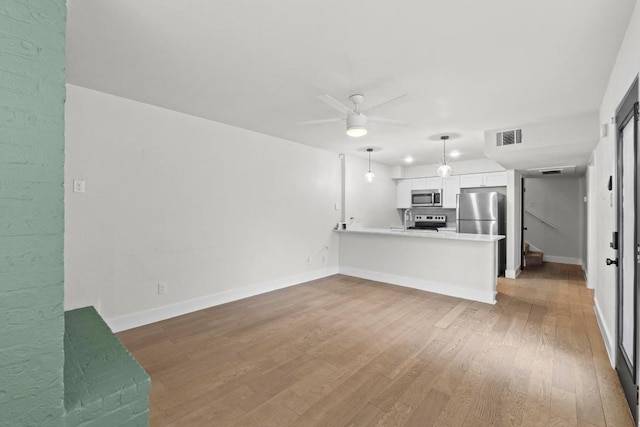 909 Reinli St Unit 101, Austin, TX 78751 - unfurnished living room featuring ceiling fan, wood finished floors, and baseboards