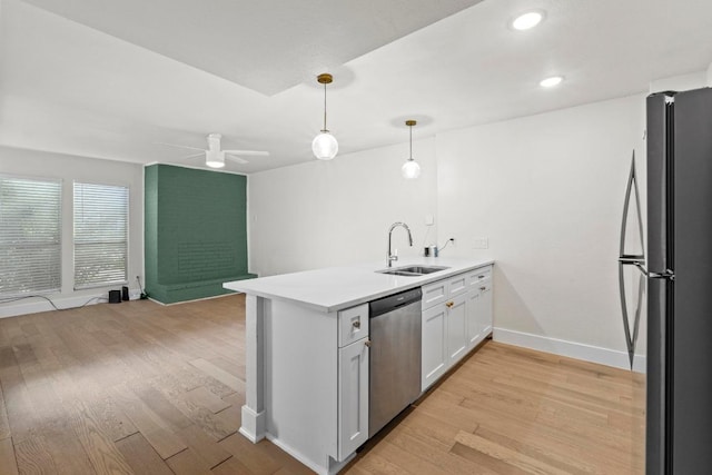 909 Reinli St Unit 101, Austin, TX 78751 - kitchen with stainless steel dishwasher, freestanding refrigerator, a peninsula, a sink, and light wood-style floors
