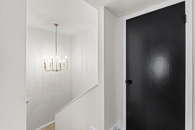 909 Reinli St Unit 101, Austin, TX 78751 - corridor featuring a chandelier and baseboards