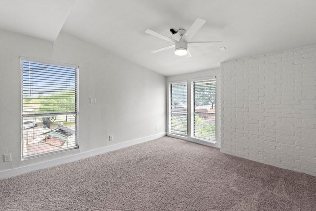 909 Reinli St Unit 101, Austin, TX 78751 - spare room with carpet flooring, a ceiling fan, lofted ceiling, and brick wall