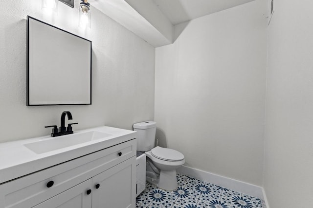909 Reinli St Unit 101, Austin, TX 78751 - half bathroom featuring toilet, vanity, and baseboards