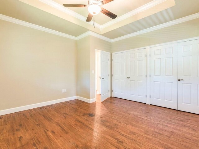 119 E Wiamea Ct, Bastrop, TX 78602 - unfurnished bedroom featuring two closets, wood finished floors, ceiling fan, and ornamental molding