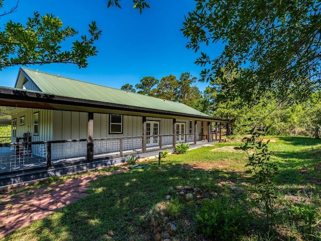 119 E Wiamea Ct, Bastrop, TX 78602 - view of front of property with french doors, a front lawn, a metal roof, and a porch