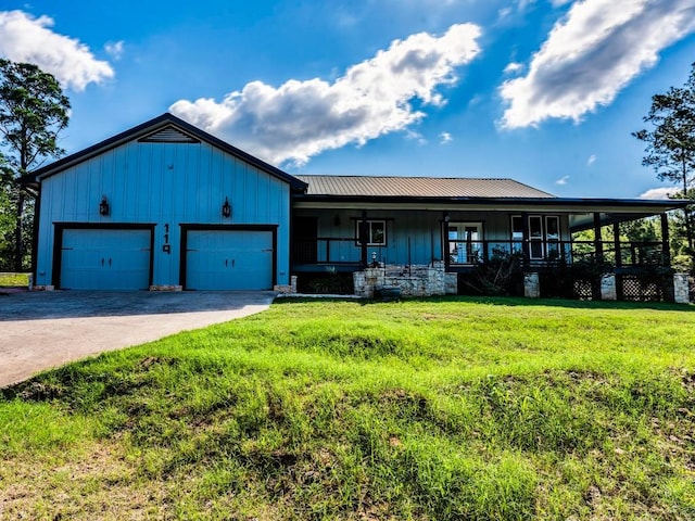 119 E Wiamea Ct, Bastrop, TX 78602 - view of front of home featuring board and batten siding, a front lawn, a porch, driveway, and a garage