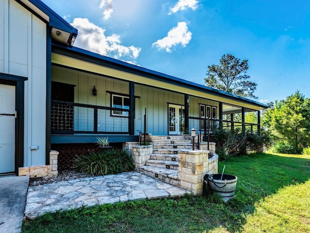 119 E Wiamea Ct, Bastrop, TX 78602 - view of front facade with board and batten siding, a front yard, french doors, and covered porch