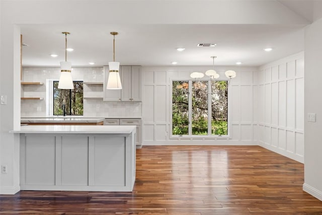kitchen with open shelves, dark wood-style flooring, light countertops, tasteful backsplash, and recessed lighting
