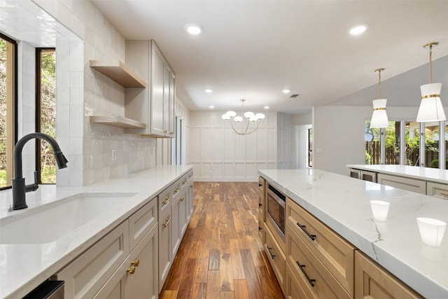 kitchen featuring open shelves, stainless steel microwave, a sink, dark wood finished floors, and backsplash