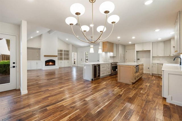 kitchen featuring beverage cooler, open floor plan, dark wood-style floors, a center island, and light countertops