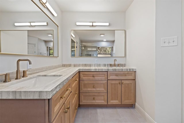 full bath with tile patterned flooring, double vanity, and baseboards