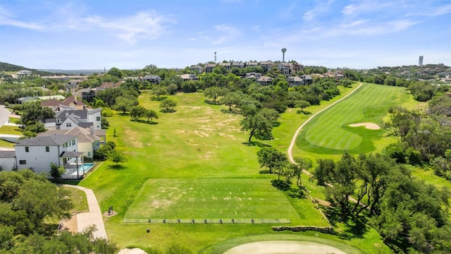 aerial view of residential area featuring a golf course and a tree filled landscape