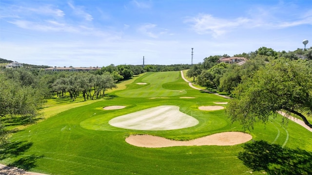 view of property's community featuring view of golf course and view of scattered trees