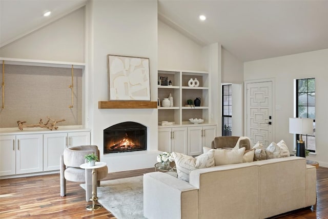 210 Hazeltine Dr, Lakeway, TX 78734 - living room with high vaulted ceiling, a warm lit fireplace, wood finished floors, and recessed lighting