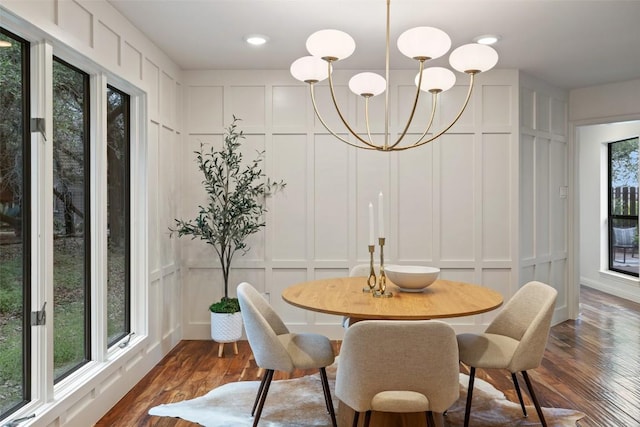 210 Hazeltine Dr, Lakeway, TX 78734 - dining room featuring a decorative wall, dark wood-style flooring, and a chandelier