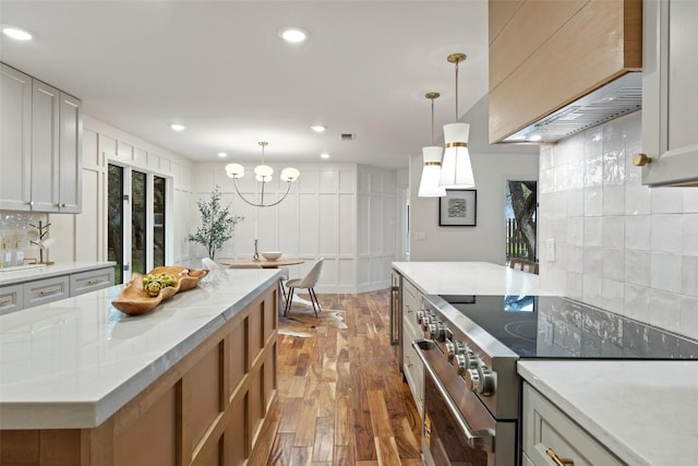 210 Hazeltine Dr, Lakeway, TX 78734 - kitchen featuring stainless steel electric range oven, wood finished floors, tasteful backsplash, hanging light fixtures, and recessed lighting