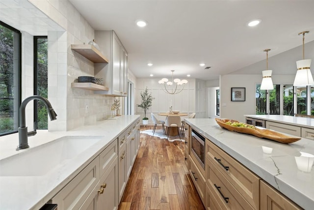 210 Hazeltine Dr, Lakeway, TX 78734 - kitchen featuring a sink, open shelves, light wood finished floors, backsplash, and decorative light fixtures