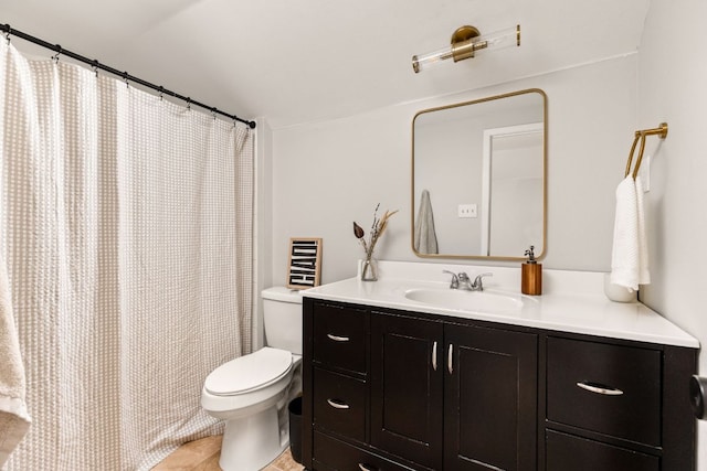 bathroom with toilet, vanity, and tile patterned floors