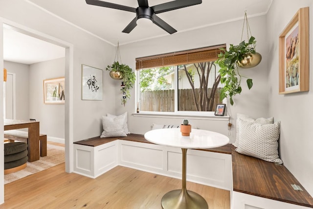 dining space featuring light wood-style flooring, ceiling fan, and crown molding