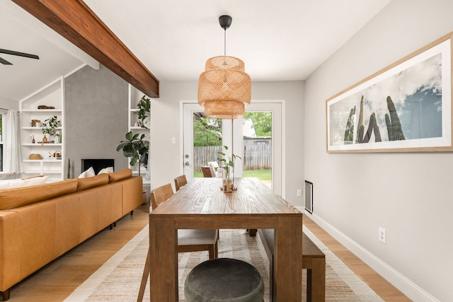 dining space with light wood finished floors, built in features, ceiling fan, and baseboards