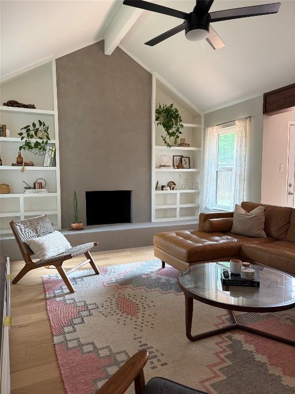 living area with wood finished floors, a ceiling fan, and built in shelves