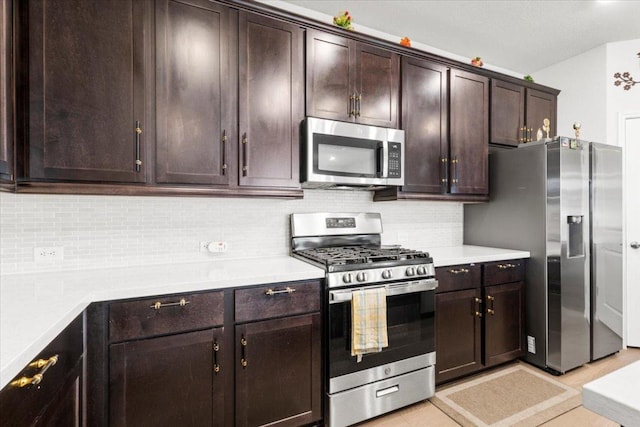 128 Green Knoll Ln, Georgetown, TX 78628 - kitchen featuring stainless steel appliances, tasteful backsplash, dark brown cabinetry, and light countertops