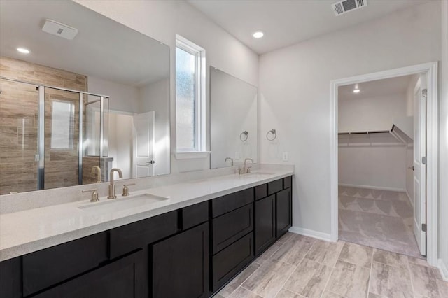 128 Green Knoll Ln, Georgetown, TX 78628 - full bath with double vanity, a shower stall, a spacious closet, and recessed lighting