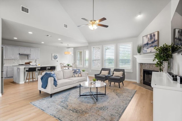 7207 Auburn Blaze Ln, Austin, TX 78744 - living area featuring lofted ceiling, light wood finished floors, a ceiling fan, a fireplace, and recessed lighting