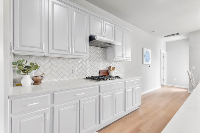 7207 Auburn Blaze Ln, Austin, TX 78744 - kitchen featuring light countertops, stainless steel gas stovetop, white cabinetry, and decorative backsplash