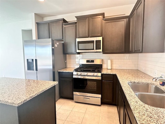 137 Rustic Glen Dr, San Marcos, TX 78666 - kitchen with stainless steel appliances, a sink, decorative backsplash, and dark brown cabinetry