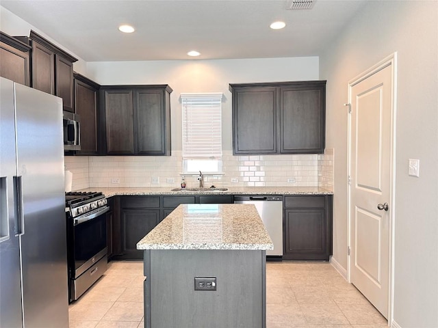 137 Rustic Glen Dr, San Marcos, TX 78666 - kitchen featuring stainless steel appliances, a sink, light tile patterned floors, a kitchen island, and recessed lighting
