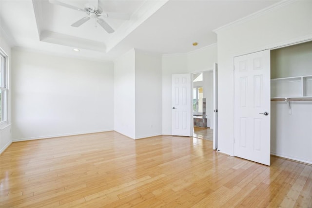 unfurnished bedroom featuring light wood-style flooring, ornamental molding, a closet, a ceiling fan, and baseboards