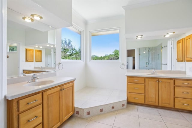 full bath featuring tile patterned floors, a stall shower, two vanities, and ornamental molding