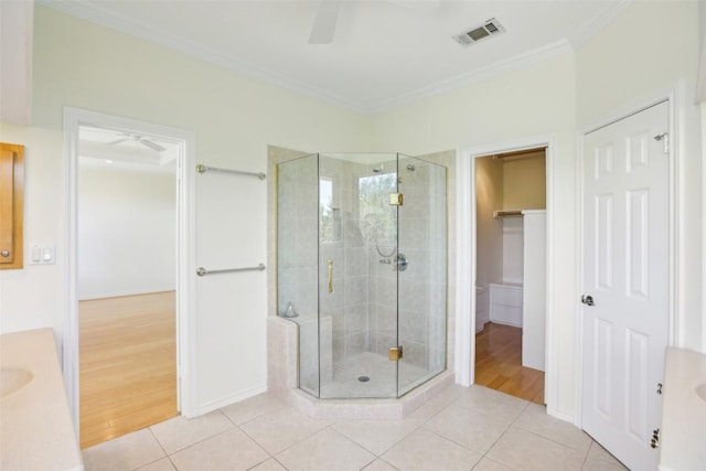 full bathroom featuring ceiling fan, a shower stall, tile patterned floors, and ornamental molding