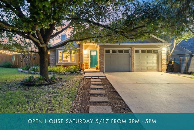 view of front of home with driveway, an attached garage, brick siding, and fence