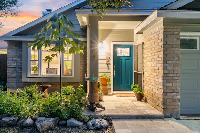 view of exterior entry featuring brick siding