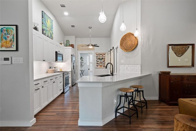 8304 Avocet Dr, Austin, TX 78745 - kitchen with appliances with stainless steel finishes, a sink, a peninsula, a breakfast bar, and decorative backsplash