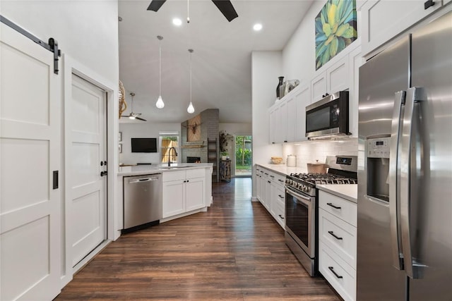 kitchen featuring stainless steel appliances, a ceiling fan, light countertops, backsplash, and vaulted ceiling