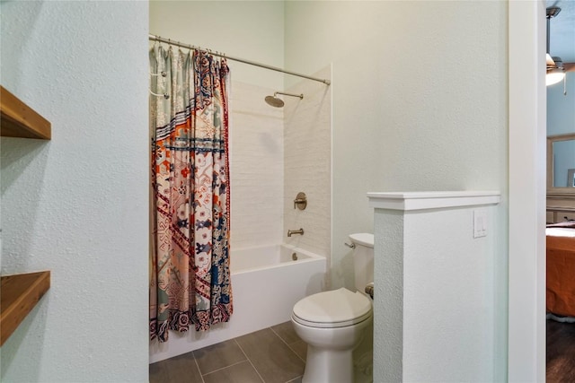 bathroom featuring shower / tub combo, toilet, and a textured wall