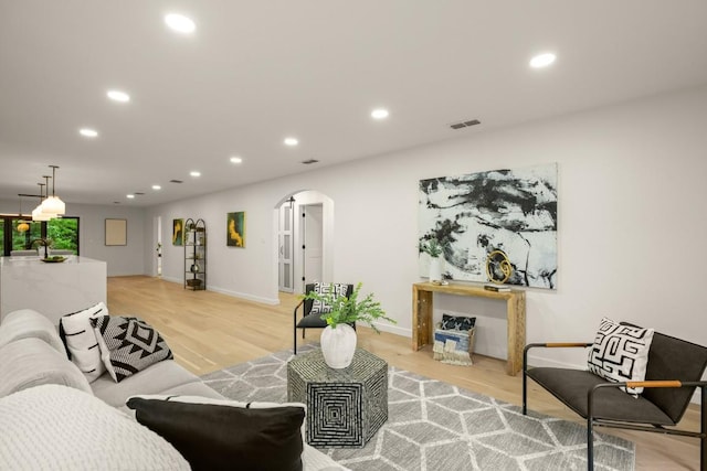 1811 Rogge Ln, Austin, TX 78723 - living area with arched walkways, recessed lighting, light wood finished floors, and baseboards