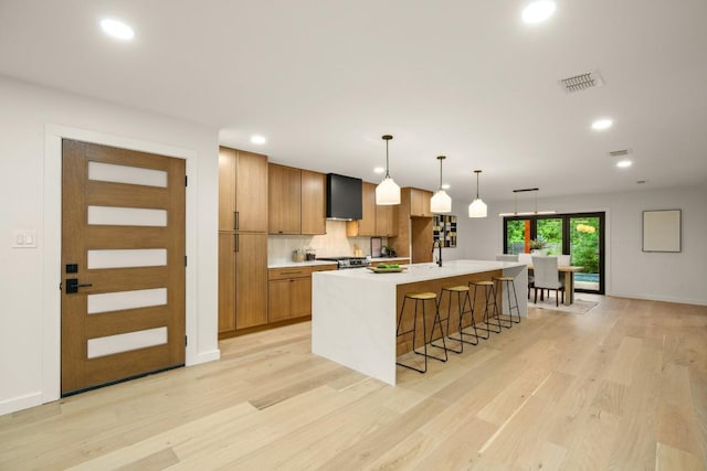 1811 Rogge Ln, Austin, TX 78723 - kitchen featuring a large island, light wood-style floors, light countertops, recessed lighting, and a kitchen bar