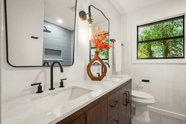 1811 Rogge Ln, Austin, TX 78723 - full bathroom featuring double vanity, toilet, baseboards, and tile patterned flooring