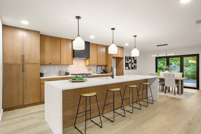 1811 Rogge Ln, Austin, TX 78723 - kitchen featuring a sink, light wood-style floors, stove, wall chimney exhaust hood, and light countertops