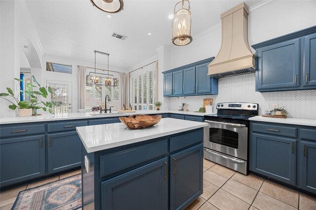 kitchen with stainless steel range with electric stovetop, a sink, blue cabinets, and crown molding