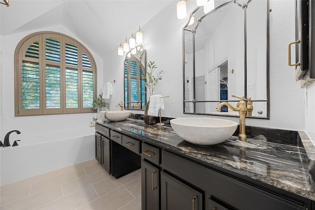 full bathroom with tile patterned floors, double vanity, a garden tub, and vaulted ceiling