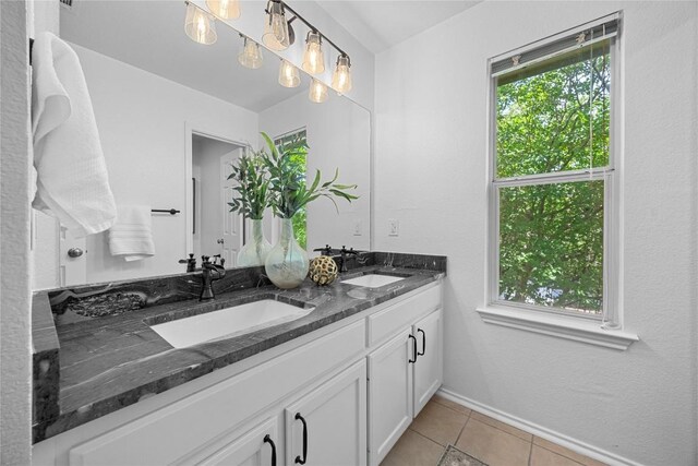 bathroom featuring double vanity, tile patterned flooring, and baseboards