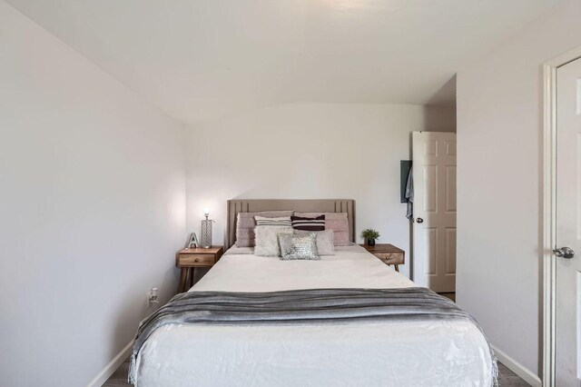 bedroom featuring vaulted ceiling and baseboards