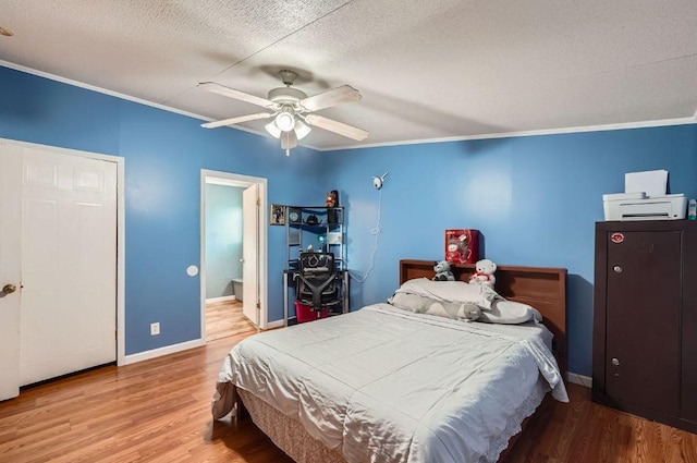 bedroom featuring wood finished floors, crown molding, a textured ceiling, baseboards, and ceiling fan