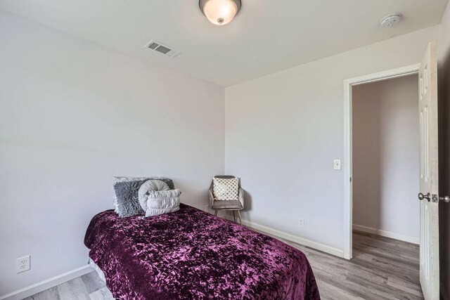 bedroom with light wood-style floors and baseboards