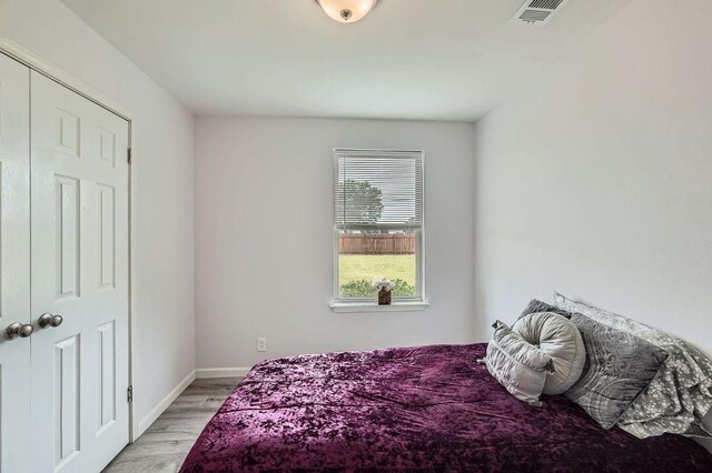 bedroom with light wood-type flooring and baseboards